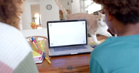 Mother and Son Bonding over Laptop with Curious Cat