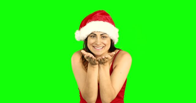 Smiling Woman Wearing Santa Hat Blowing Kiss on Green Background - Download Free Stock Images Pikwizard.com