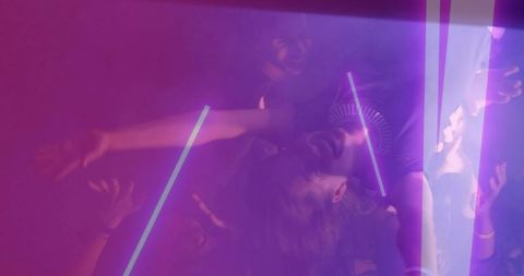 Neon-lit crowd dancing, tilting heads and raising hands under purple haze with neon tubes