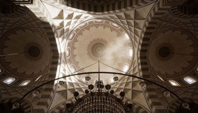 Ornate mosque dome with central medallion and grand crystal chandelier