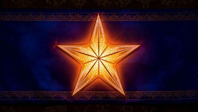 Glowing paper star lantern casting warm halo on deep blue textile with gold border