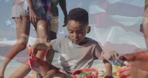 Young Boy Playing in Sand at Beach with Patriotic Theme