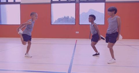 Young boys balancing while stretching in school gym