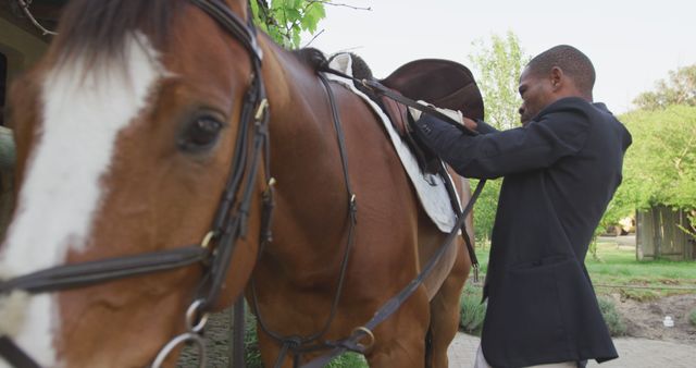 Man Preparing Horse for Ride with Saddle Outdoors - Download Free Stock Images Pikwizard.com