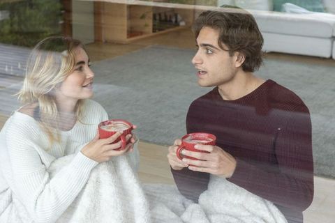 Cozy Couple Enjoying Warm Drinks Indoors by Window