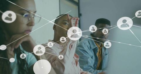 Professionals collaborating on virtual user-network interface with digital icons overlay