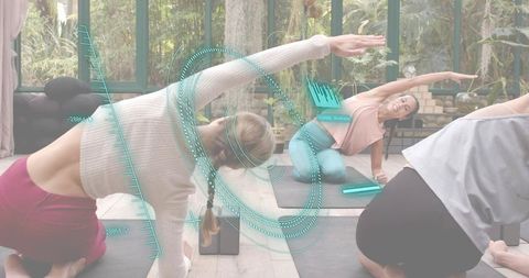 Instructor leading group yoga class with wearable tech overlay in sunlit greenhouse studio