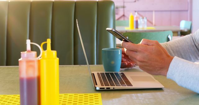 Person Working on Laptop in Cozy Cafe with Condiments - Download Free Stock Images Pikwizard.com