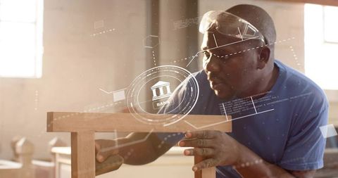 Mature Carpenter Sanding Wooden Stool in Workshop with Augmented Reality Banking Interface