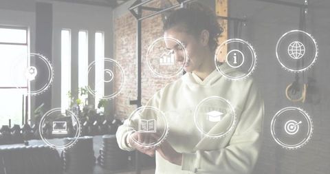 Woman checking smartwatch in industrial gym with fitness hud overlay and kettlebells