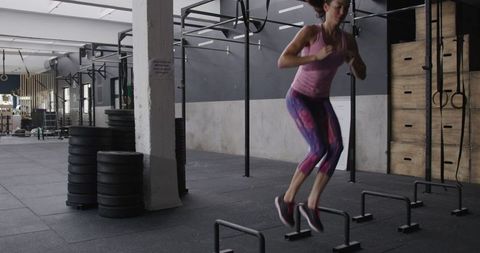 Athletic Woman Performing Jumping Exercise in Gym