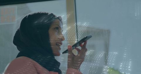 Muslim Businesswoman Interacting with Digital Technology in Modern Office With Glass Window