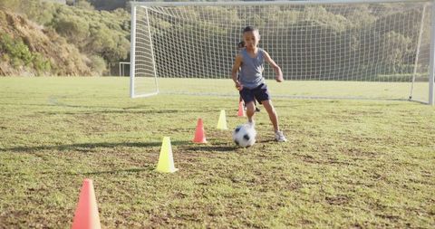 Boys Practicing Soccer Drills on Outdoor Field with Cones