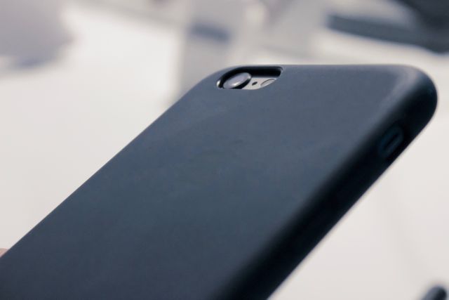 Close-up view of sleek smartphone in protective black case. Ideal for technology blogs, mobile device advertisements, accessory reviews, and minimalist design themes.
