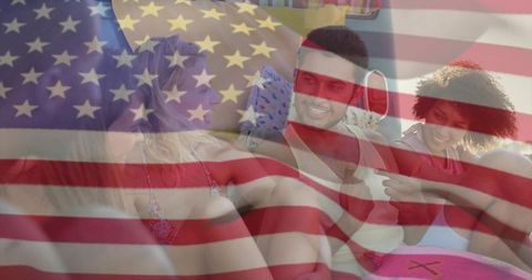 Friends laughing lounging in swimwear with american flag overlay summer gathering