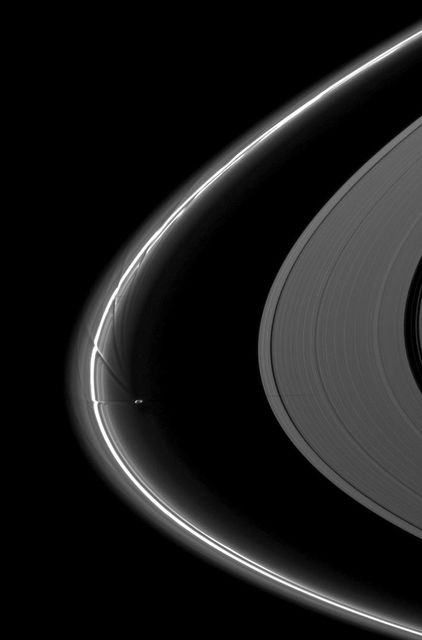 Photograph of Saturn's moon Prometheus creating streamer-channels in the F ring, casting shadow on A ring. Can be used for educational material, astronomical studies, presentations, space exploration documentaries, or as desktop wallpaper.