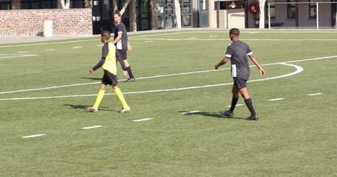 Young soccer players practicing on field with coach nearby