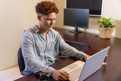 Male Professional Working on Laptop in Modern Office