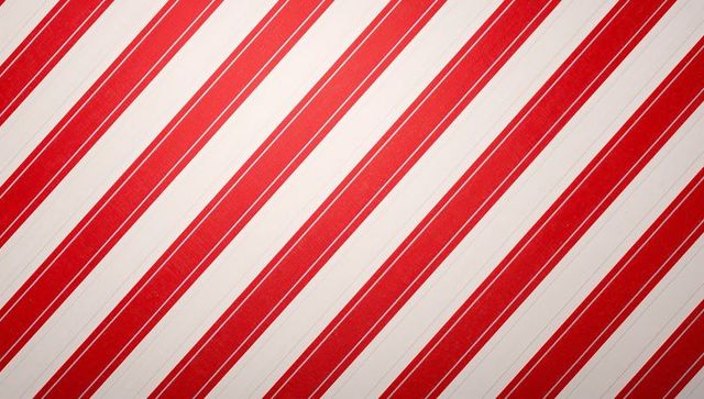 Diagonal red and cream striped pattern with subtle texture for retro candy-stripe designs