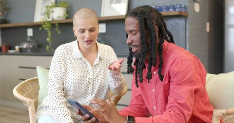 Sharing smartphone ideas, diverse friends collaborating in cozy modern kitchen lounge