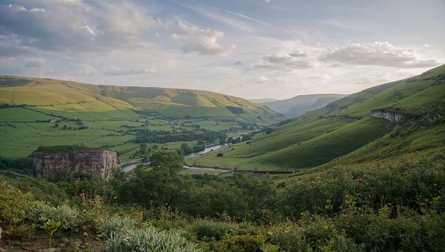 Winding river valley at dusk with limestone outcrop and rolling green hills