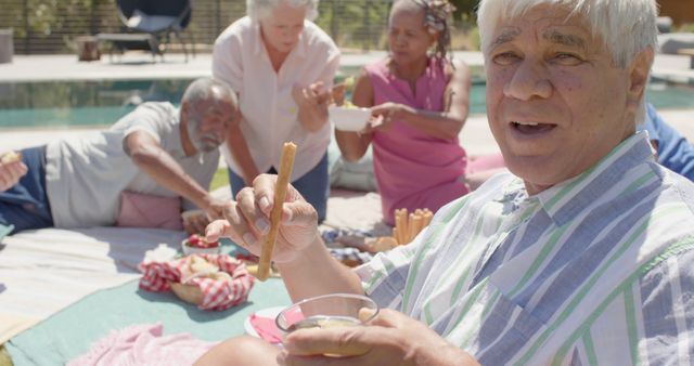 Smiling Senior Friends Enjoying Outdoor Picnic Near Pool - Download Free Stock Images Pikwizard.com