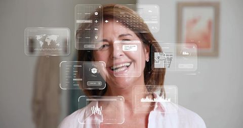 Laughing senior woman interacting with translucent ar interfaces in modern home interior