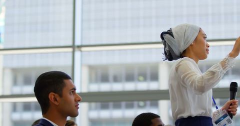 Businesswoman Engaging in Corporate Seminar With Microphone Interaction