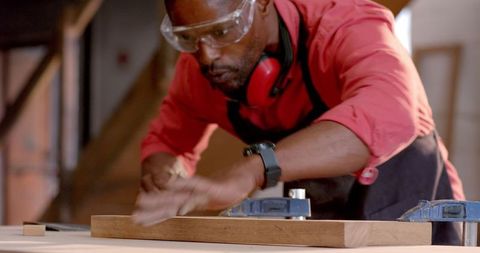 Experienced craftsman expertly planing wood in workshop