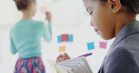 Young Girl Writing in Notebook During Creative Classroom Activity - Download Free Stock Images Pikwizard.com