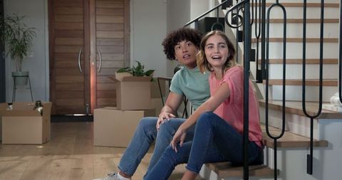 Young Couple Planning New Home Surrounded by Moving Boxes