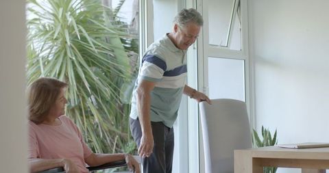 Senior Couple and Young Man Having Conversation at Home