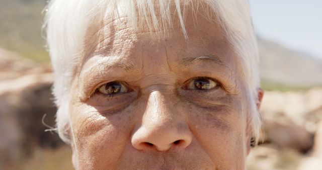 Close-up of eyes of caucasian senior woman standing on rocks. Retirement, vacations, summer,active senior lifestyle, unaltered.