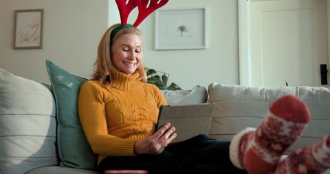 Joyful Senior Woman Celebrating Christmas with Tablet