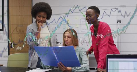 Diverse Businesswomen Analyzing Financial Charts in Modern Office