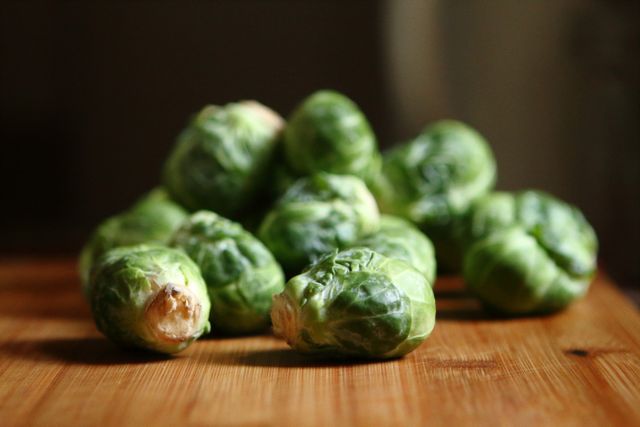Fresh Brussels Sprouts on Wooden Surface - Download Free Stock Photos Pikwizard.com