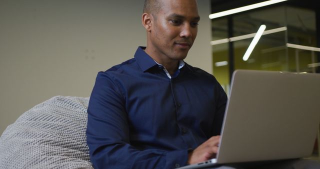 Smiling Biracial Businessman Working on Laptop in Modern Office Environment - Download Free Stock Images Pikwizard.com