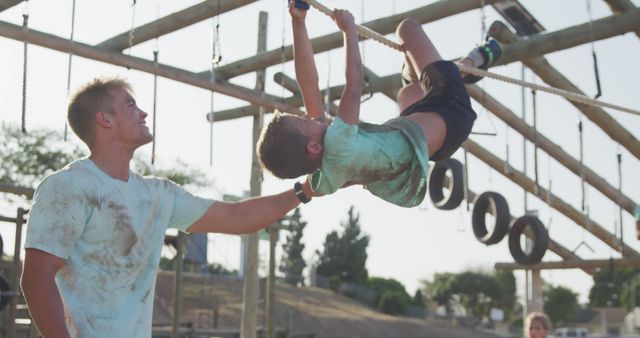 Father Supporting Son Climbing Obstacle Course Outdoors - Download Free Stock Images Pikwizard.com