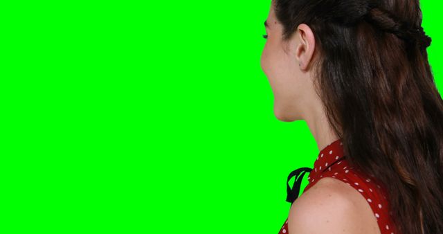 Young woman smiling against green screen