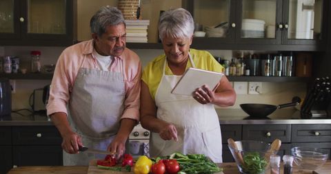 Senior Couple Joyfully Cooking Together in Home Kitchen