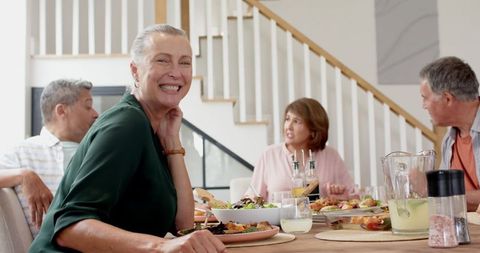 Mature Friends Enjoying Lunch in Cozy Dining Room Set-Up