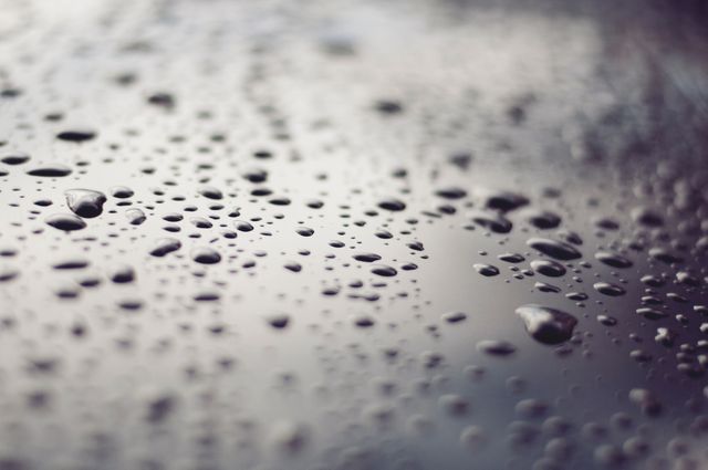 Water droplets on a glass surface depicted in a close-up, macro perspective. Useful for backgrounds, presentations, websites, environmental themes, freshness concepts, and water conservation topics.