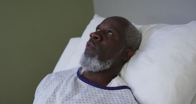 African american male patient lying in hospital bed and yawning - Download Free Stock Photos Pikwizard.com