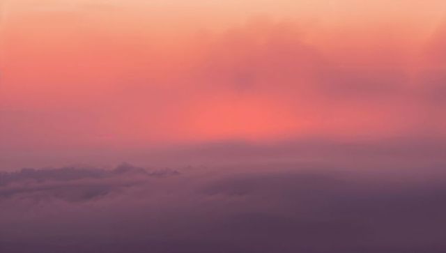 Majestic purple clouds with sunrise glow in high altitude view