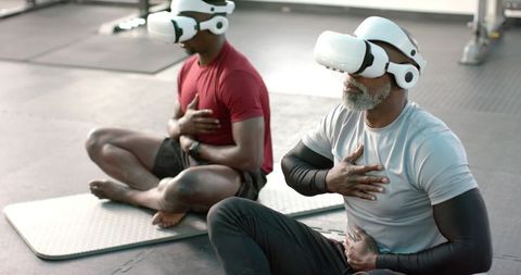 African american senior and adult men practicing vr-guided breathwork and seated meditation