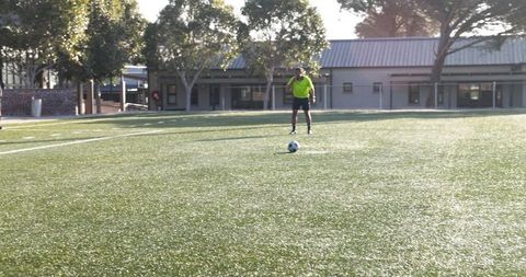 Boys Enjoying Soccer Match on School Field in Sunshine