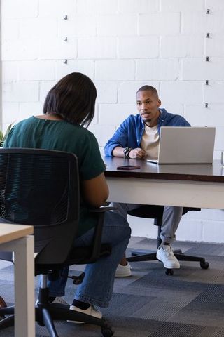 African american coworkers conducting one-on-one meeting in modern minimalist office