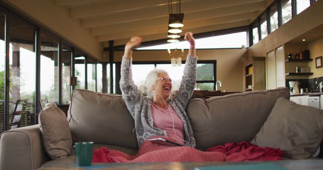 Excited Elderly Woman Cheering on a Couch in Modern Living Room - Download Free Stock Images Pikwizard.com