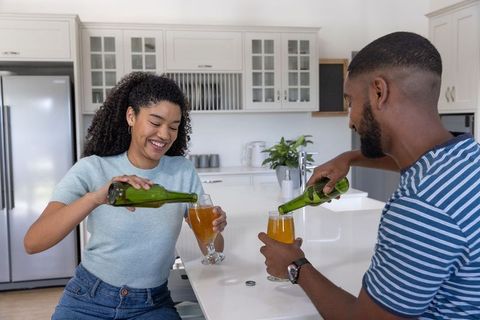 Happy Couple Enjoying Beverages at Home in Modern Kitchen
