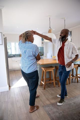 Senior Couple Dancing Joyfully in Bright Kitchen Interior